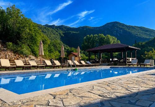 a pool at a resort with chairs and a gazebo at Etno Selo Grabovicka Jutra in Cetinje