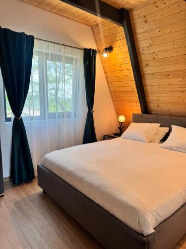 a bedroom with a large bed and a window at Nature View Breaza in Breaza de Sus