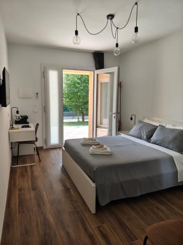 a bedroom with a bed and a desk and a window at PiaveHome in San Donà di Piave