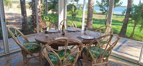 a wooden table and chairs on a porch with a view of the ocean at Le Refuge in Larache