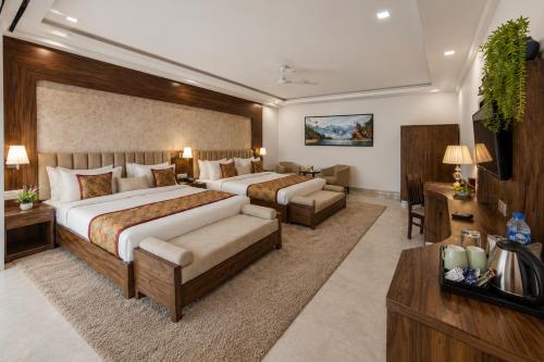 a hotel room with two beds and a couch at Hotel The Prithvi Delhi Airport With Free Airport Pic Up in New Delhi