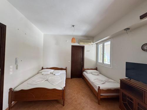two beds in a room with a tv and a room with at The Countryside in Sarandë