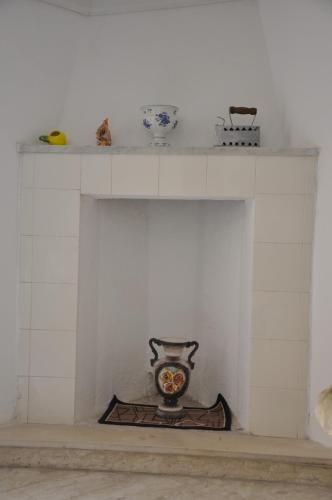 a white fireplace with a shelf on top of it at Nonna Rosa's Apartment in Pisticci