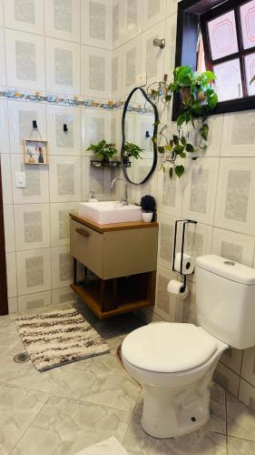 a bathroom with a toilet and a sink at Suíte privativa - Centro Guararema in Guararema