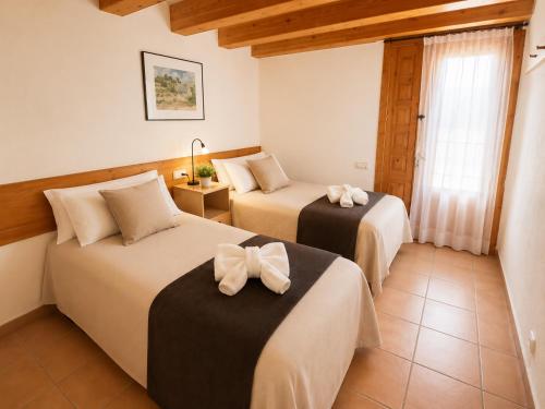 a room with two beds with bows on them at El Cajigar Ordesa Aínsa in Laspuña