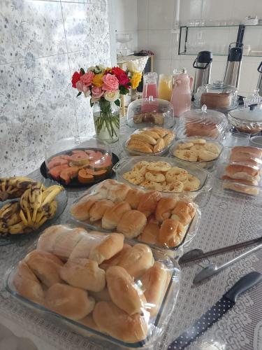 a table with many different types of bread and pastries at Bom Viver Pousada-Viçosa do Ceará -CE in Viçosa do Ceará