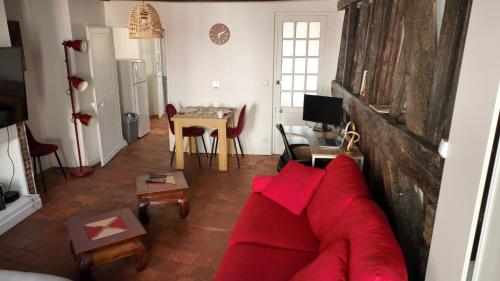 a living room with a red couch and a table at Appart proche gare centre ville bureau parking in La Loupe