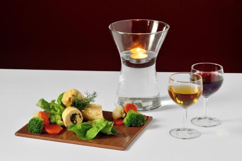 a plate of vegetables and a glass of wine at Hotel Gracja in Kuźnia Raciborska