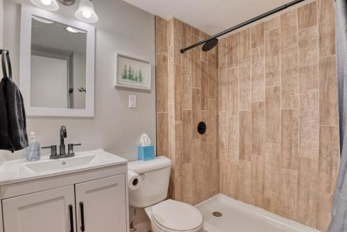 a bathroom with a shower and a toilet and a sink at Fox Den Cozy Mountain Apt In GMF in Green Mountain Falls