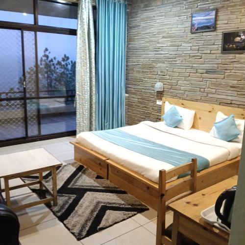 a bedroom with a bed and a large window at Rudraa Himalayan Retreat in Hawālbāgh