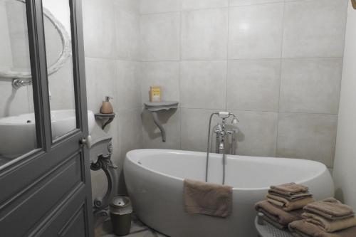 a bathroom with a bath tub and a sink at Le Piano in Biesles