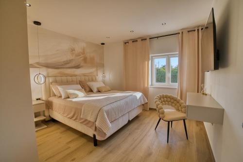 a bedroom with a bed and a chair and a window at Villa de Pucci in Žminj