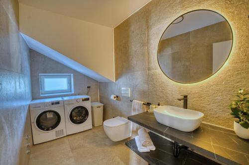 a bathroom with a washing machine and a sink at Villa de Pucci in Žminj