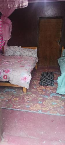 a bedroom with a bed and a door with a rug at Lebentera camp in Narok