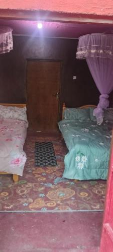 a bedroom with two beds and a door with a curtain at Lebentera camp in Narok