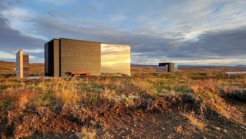 a building in the middle of a field at Mystic Light Lodge in Búðardalur