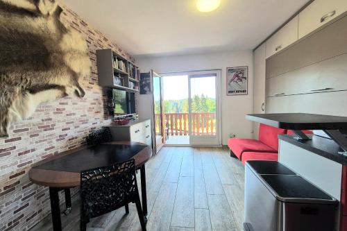 a kitchen and living room with a red couch at Cozy apartment "WAPITI" at the foot of the slopes in Les Déserts
