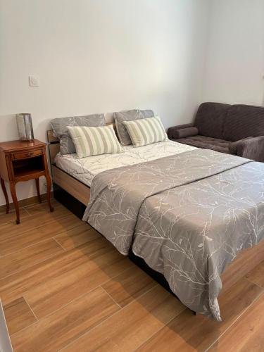 a bed in a room with a couch and a table at NovaStay in Breuillet