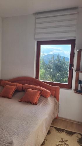 a bedroom with a bed with a large window at Hidden Haven Cottage Sarajevo in Lokve