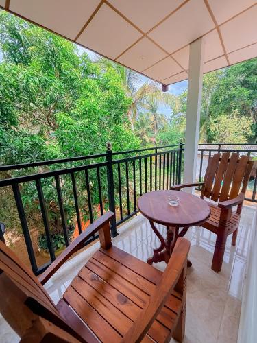 a balcony with two chairs and a table on a balcony at Deer Inn - Yala in Tissamaharama