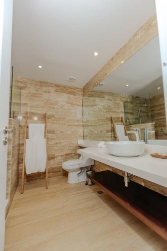a bathroom with two sinks and a toilet and a mirror at Hotel Casa Hemingway in Juan Dolio