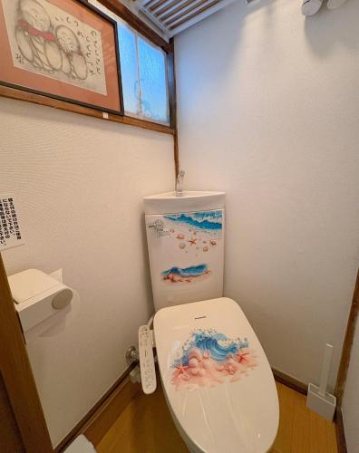 ein Badezimmer mit einer Toilette, deren Deckel unten ist in der Unterkunft Yui HOSTEL in Tokio