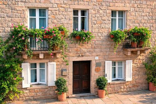 a building with potted plants and a door and windows at La Vignaredda - Residenza di Charme in Aggius
