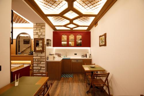 a kitchen with a skylight and a table and chairs at Vila Mantho in Gjirokastër