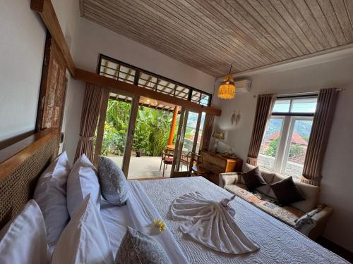 a bedroom with a bed in a room with windows at Kanda Homestay in Sidemen