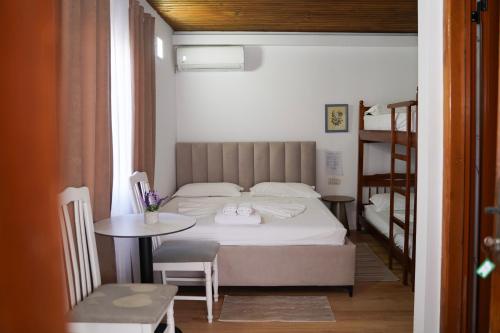 a bedroom with a bed and a table and a chair at ARBERs aparthotel in Durrës