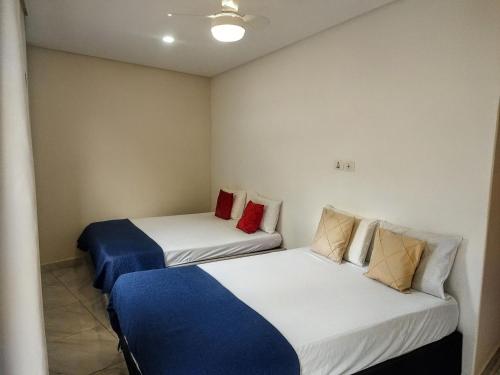 two beds in a small room with two at Refúgio com Churrasqueira na Praia in Bertioga