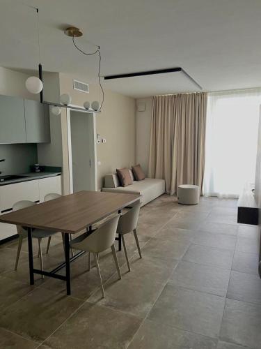 a kitchen and living room with a wooden table and chairs at ALandGIO Smart Stay in Cavallino-Treporti