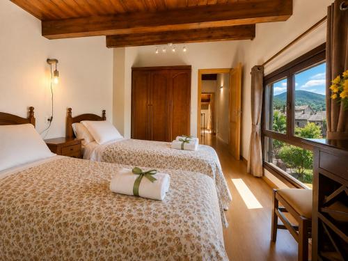 a hotel room with two beds and a window at Duplex La Valle Ordesa-Ainsa in Laspuña