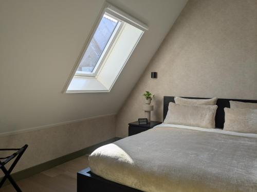 a bedroom with a large bed and a window at B&B Het Houten Huis in Brandwijk
