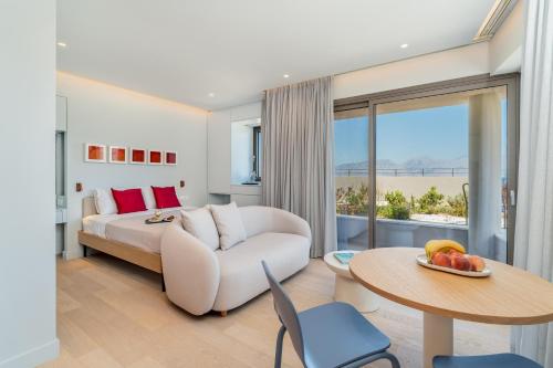 a bedroom with a bed and a table and a couch at NOMIA Seaside Living in Agios Nikolaos