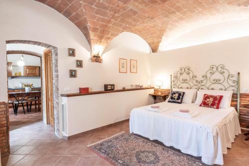 a bedroom with a bed and a dining room at Le ginestre 10 in Murlo
