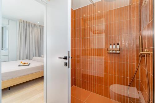a bathroom with a shower and a bed at NOMIA Seaside Living in Agios Nikolaos