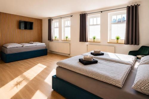 a bedroom with two beds and two windows at Hotel & Restaurant Hasa in Gernrode - Harz