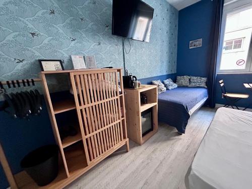 a small room with a bed and a small bedroom at Hôtel Le Petit Baigneur in Palavas-les-Flots