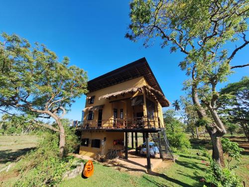a house in the middle of a field with trees at The Loft by the Lake in Kurunegala