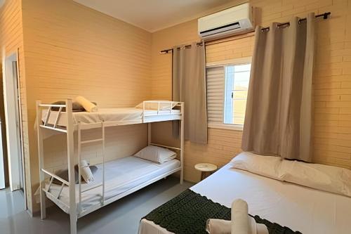 a bunk bed room with two bunk beds in it at 2 Suítes com Ar e Cozinha Completa in Andradina