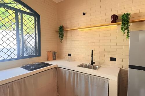 a kitchen with a sink and a window at 2 Suítes com Ar e Cozinha Completa in Andradina