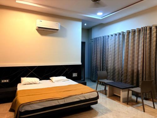 a bedroom with a bed and a air conditioner on the wall at Hotel VITHAI PALACE in Mehekar