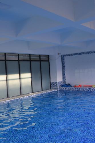 a swimming pool in a building with a blue floor at Meteor gardens in Nairobi