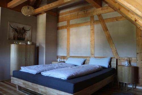 a large bed in a room with wooden ceilings at Ferienwohnung Am Tharandter Wald 2 in Wilsdruff