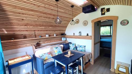 a living room with a couch and a table at Tiny house chez Manou in Castelnau-de-Mandailles