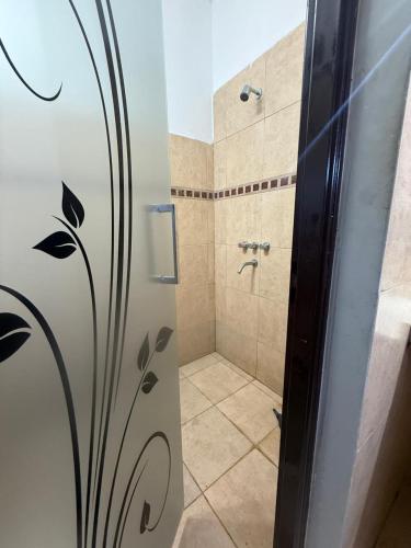 a bathroom with a shower with a glass door at Richard House in Villa Dolores