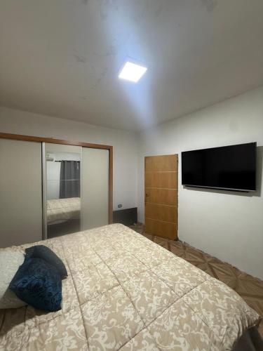a bedroom with a large bed and a flat screen tv at Richard House in Villa Dolores