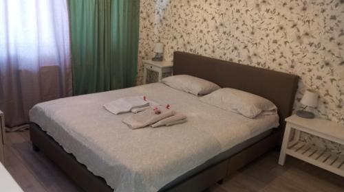 a bedroom with a bed with towels on it at Green Apartman in Čukarica