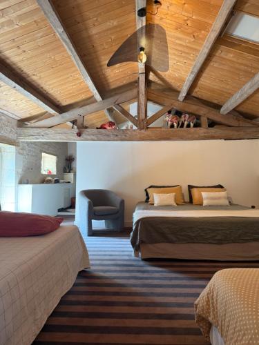 a bedroom with two beds and a ceiling fan at Le loft chambre et salon climatisés in Croix-Chapeau